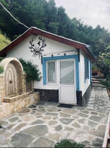 mały dom z drzwiami i kamiennym patio w obiekcie Cozy Home in Ardino w mieście Ardino