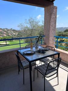 a table and chairs on a balcony with a view at Le Mazet des maisons du golf in Sainte-Maxime