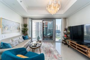 a living room with a couch and a large television at Spectacular Views of Burj & Fountain - 2 BR in Dubai