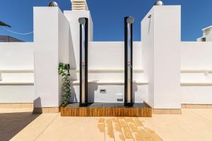a white building with black poles and a plant at Allo Apartments San Roque 1ºA in Cádiz +33 photos