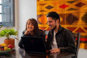 um homem e uma mulher sentados numa mesa com um portátil em La Banksia Hotel em Quito