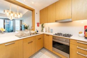 a kitchen with wooden cabinets and a sink and a stove at Spectacular Views of Burj & Fountain - 2 BR in Dubai
