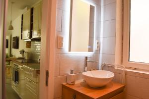 - une salle de bains avec un bol sur une table en bois dans l'établissement Fontainas Apartments, à Bruxelles