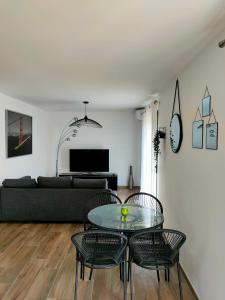 a living room with a glass table and chairs at Jardin et 2 chambres centre St Florent in Saint-Florent