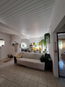 - un salon avec un canapé blanc dans l'établissement Casa Verde Piscina Spa com Ofurô e Hidro 750m Cavalhodromo 1km Rua do Lazer Reserva Florestal no quintal TVs com Premiere Futebol Filmes You Tube Churras Fogão a lenha Ar Split Internet Fibra Mercado Pirineus Pets bem vindos sossego e energia boa, à Pirenópolis