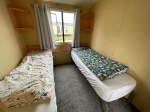 a small room with two beds and a window at Peaceful holiday home on a park on the Kent Coast in St Margarets at Cliff