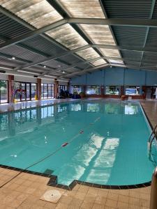 a large indoor swimming pool with blue water at Peaceful holiday home on a park on the Kent Coast in St Margarets at Cliff