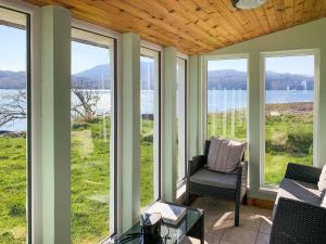 a screened in porch with a couch and chairs and windows at The House On The Point - Uk43807 in Kylerhea