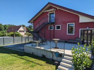 une maison rouge avec un escalier devant elle dans l'établissement Anton's bunte Welt (100 m², Parkplatz, Garten und viel mehr), à Albersdorf