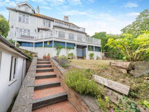 a large white house with stairs in front of it at The Cottage in St Margarets at Cliff