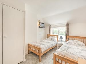 a bedroom with two beds and a mirror at Dovedale Cottage in Coningsby