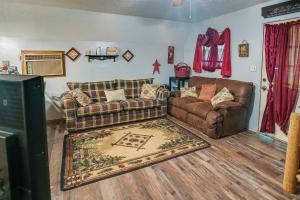 a living room with two couches and a rug at Cozy Country Cabin 4 Mi to Cave Run Lake! in Wellington