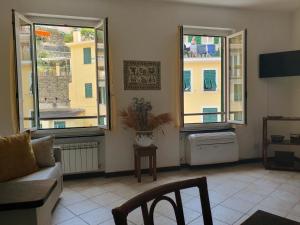 a living room with two windows and a couch at LA CASA DI MINA in Vernazza