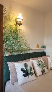 ein Schlafzimmer mit einem Bett mit Kissen und Pflanzen an der Wand in der Unterkunft Presolana Suite in Love casa vacanza in Castione della Presolana