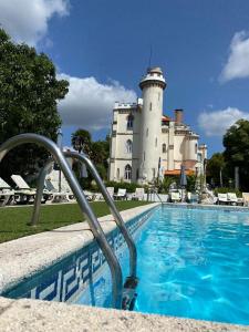 a pool in front of a building with a lighthouse at Vila Aurora in Luso