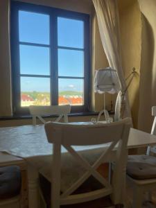 uma sala de jantar com uma mesa e cadeiras e uma janela em Residence Spillenberg Bridal Suite - Svadobna cesta em Levoča