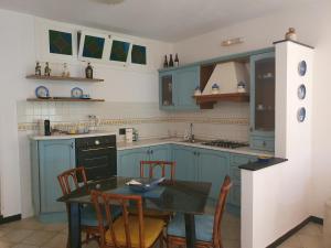 cocina con armarios azules, mesa y sillas en LA CASA DI MINA, en Vernazza