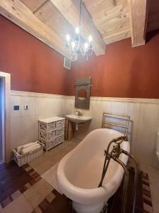 Residence Spillenberg Bridal Suite - Svadobna cesta في ليفوتشا: حمام مع حوض استحمام ومغسلة