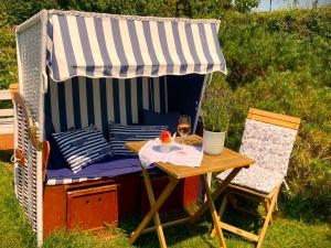 an outdoor table with a umbrella and a glass of wine at Auszeit am Haffufer in Wilhelmshof