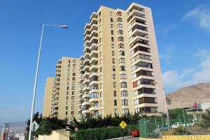 un edificio de apartamentos alto con montañas en el fondo en Apartamento Altos del Mar, en Antofagasta