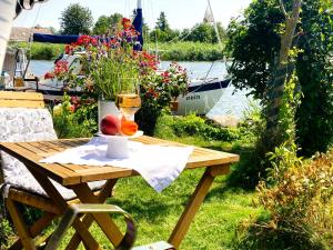 a picnic table with a glass of wine and fruit on it at Auszeit am Haffufer in Wilhelmshof