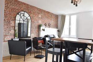 comedor con pared de ladrillo, mesa y sillas en Fontainas Apartments en Bruselas