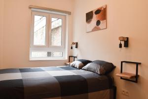 1 dormitorio con cama y ventana en Fontainas Apartments en Bruselas