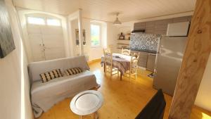 a living room with a couch and a kitchen at LA FLOCLEVAL in Le Chambon-sur-Lignon