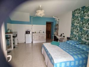 1 dormitorio con 1 cama y cocina. en Charmant petit havre de paix en Dauphin