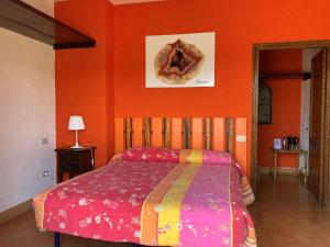 1 dormitorio con cama y pared de color naranja en Agriturismo Gioie di Campagna, en Fabriano