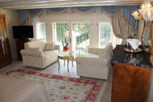 a living room with two chairs and a couch and a tv at Hotel Palazzo Abadessa in Venice