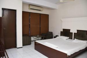 1 dormitorio con 1 cama grande y 1 mesa en HOTEL GOMTI, en Nagpur