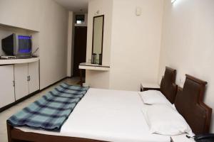 1 dormitorio con 1 cama y TV en la barra en HOTEL GOMTI, en Nagpur