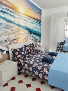 um quarto com uma cama e uma pintura do oceano em Nuovo bilocale a 150 mt dal mare em Porto Torres
