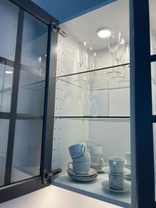 a glass cabinet with dishes and wine glasses at Lakeside Traunsee Apartment in Altmünster