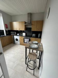 a kitchen with a table and a chair in it at Homely 3 bed town centre flat in Peterhead