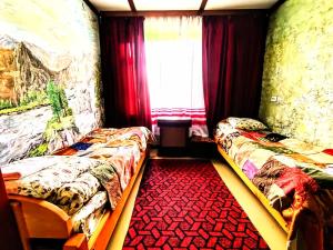 - une chambre avec 2 lits, une fenêtre et un tapis rouge dans l'établissement LAILA Guest House, à Mestia