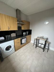 a kitchen with a washing machine and a table at Homely 3 bed town centre flat in Peterhead