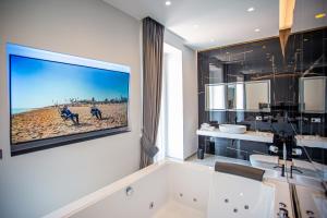 a bathroom with a large tv hanging on the wall at Forever Luxury Rooms in Castellammare di Stabia