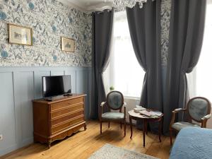 een slaapkamer met een tv, een dressoir en een raam bij La Boulonnaise in Boulogne-sur-Mer