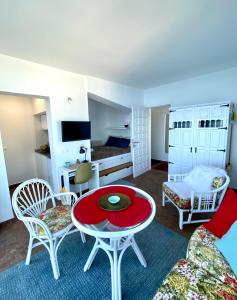 ein Wohnzimmer mit einem Tisch, Stühlen und einem Bett in der Unterkunft Villa Oasis La Paz - Pelinor Studio - ADULTS ONLY in Puerto de la Cruz