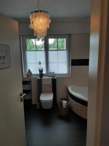 a bathroom with a tub and a toilet and a sink at Seeliebe mit Sauna und nur 50 mtr. bis zum Strand in Senftenberg