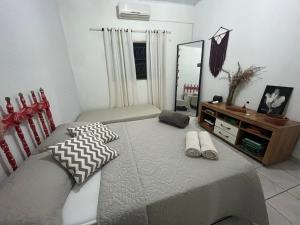 une chambre avec un lit avec un miroir et une chaise dans l'établissement Casa Verde Piscina Spa com Ofurô e Hidro 750m Cavalhodromo 1km Rua do Lazer Reserva Florestal no quintal TVs com Premiere Futebol Filmes You Tube Churras Fogão a lenha Ar Split Internet Fibra Mercado Pirineus Pets bem vindos sossego e energia boa, à Pirenópolis 15 autres photos