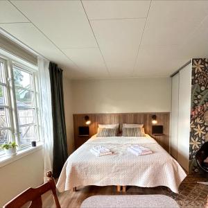 una camera da letto con un letto e due asciugamani di Havsbadens B&B ad Ängelholm