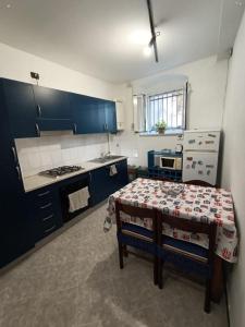 eine Küche mit blauen Schränken und einem Tisch darin in der Unterkunft Dai Pescatori Nervi in Genua