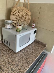 a microwave on a counter with a basket on top at Departamentos Cristo del Portezuelo in Chilecito