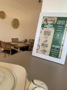 a sign for a coffee restaurant with tables and chairs at Departamentos Cristo del Portezuelo in Chilecito