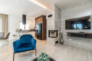 a living room with a blue chair and a fireplace at Exclusive luxury Villa with glorious sea view - by TA Leut Agency in Privlaka
