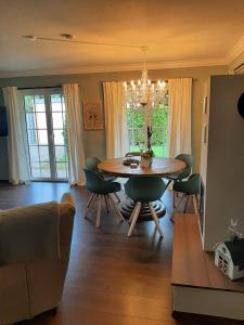 a living room with a dining room table and chairs at Seeliebe mit Sauna und nur 50 mtr. bis zum Strand in Senftenberg