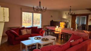 una sala de estar con sofás rojos y una mesa. en Domaine des Aulnaies - Beauval - Mareuil sur Cher, en Mareuil-sur-Cher